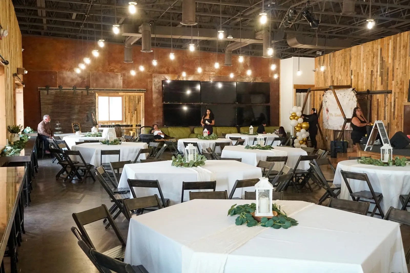 Emerald Eve event hall set up with white tablecloths and string lights